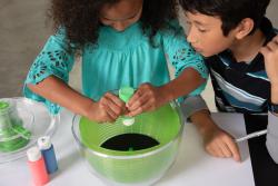 Girl using paint in nebula spin art activity