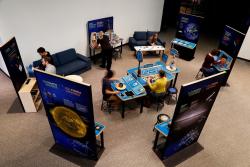 Sun, Earth, Universe exhibition Birdseye view of visitors interacting with exhibits