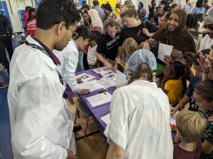 Greensboro Science Center family science night with families crowded around an hands-on activity table