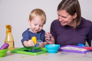 Adult and young child with water droppers using Early Explorations activity.