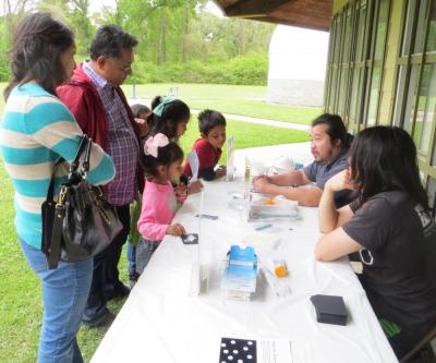 Children and adults using NanodDays Hands-on Sunblock  activity from a past NanoDays event at Highland Road Park Observatory in Baton Rouge, Louisiana 