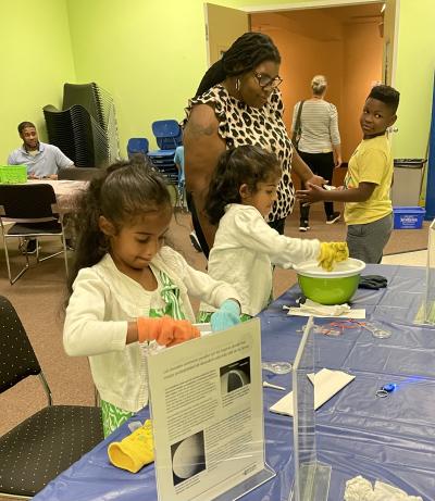 Two students engage with the Ice Orb Activity while others watch