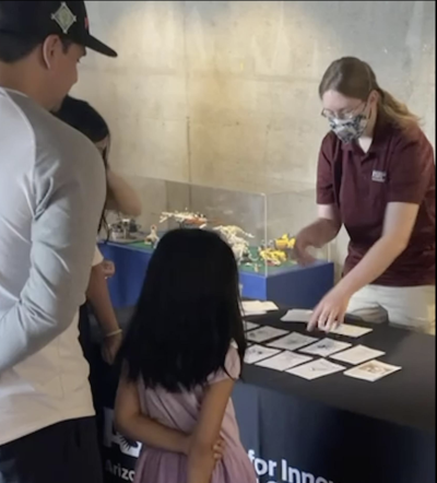 Changing Brains Neuro Futures Card Game with masked facilitator working with a child and caregiver