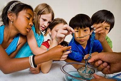 Educator and group of children learning about self assembly using Gummy Capsules NanoDays activity