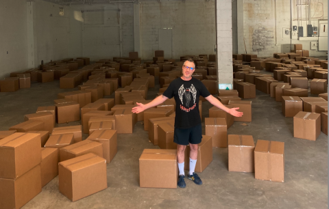 Man Standing Proudly with 350 STEM Learning Kits