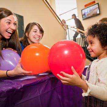 Learner smells balloons with educators