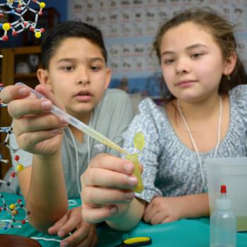 Two children extracting visible DNA from wheat germ in Building with Biology kit