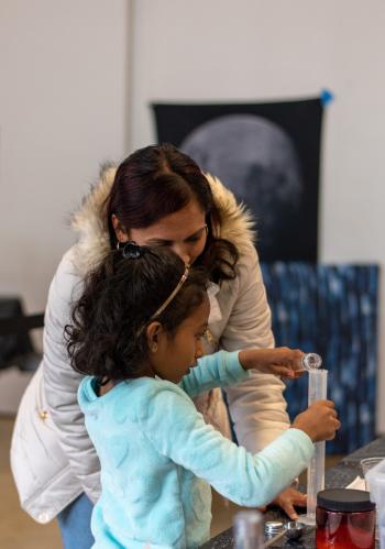 Moon Adventure Game players pouring liquid into graduated cylinder