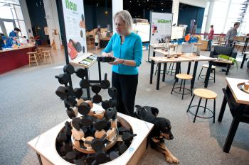 Nano exhibition blind accessibilty expert with service dog feeling tactile aspects of Build a Giant Carbon Nanotube exhibit 