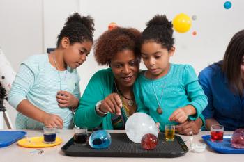 Mother and two daughters investigating giant balls of ice in Ice Orbs activity
