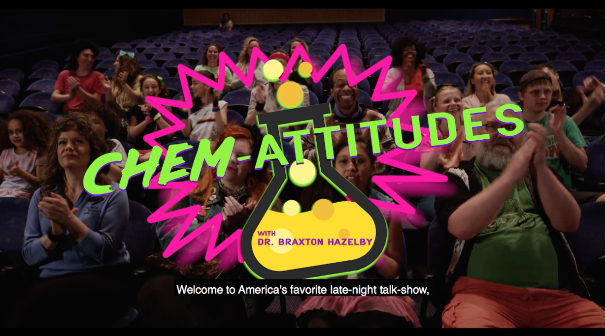 screenshot of a video opening with a live crowd seated in a theater with an overlay opening title "Chem-Attitudes"