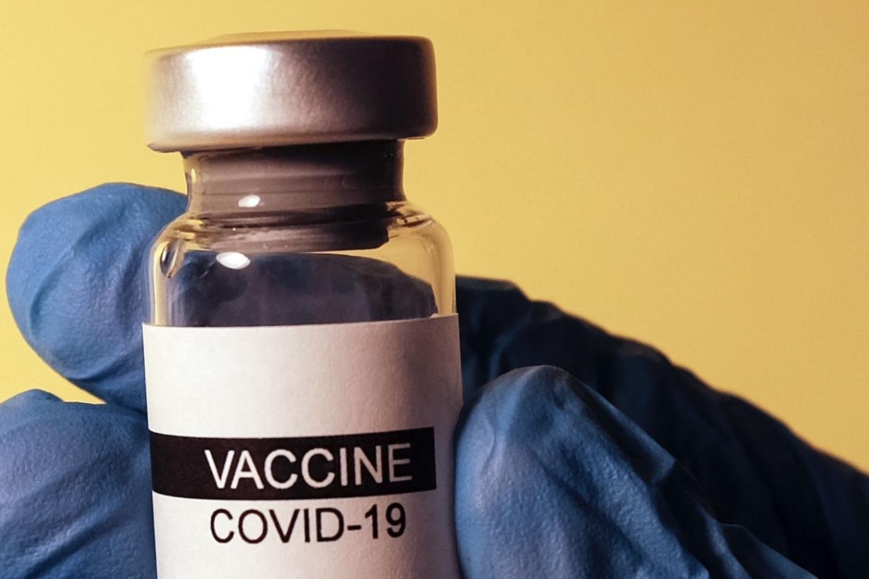 COVID vaccine vial in gloved hand Photo by Hakan Nural