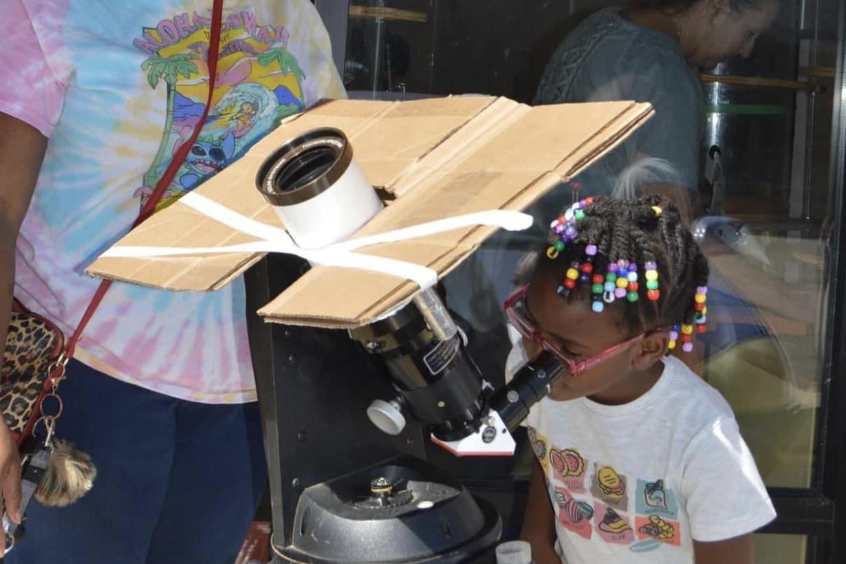 Pensacola Mess Hall in Florida event with a child looking through telescope to observe the Moon