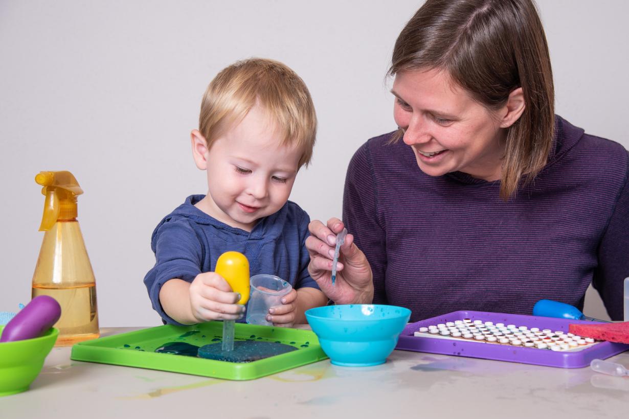 Adult and young child with water droppers using Early Explorations activity.