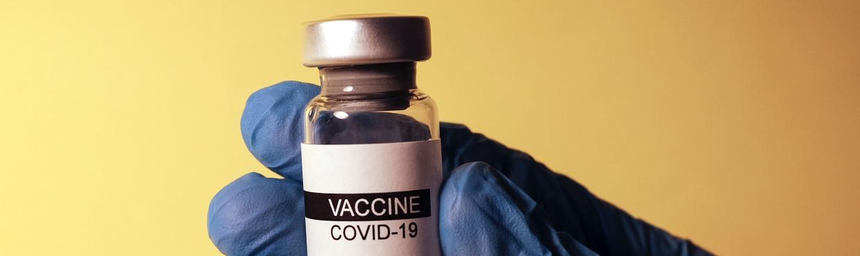COVID vaccine vial in gloved hand Photo by Hakan Nural