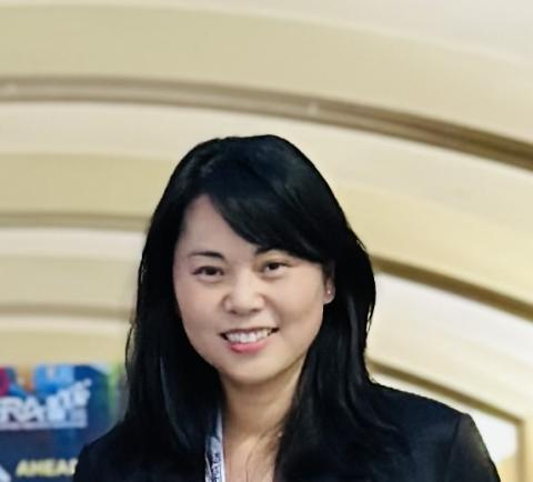 Headshot for Dr. Tingting Reid, an individual with long dark hair appears from the shoulders up on a light background that is textured but ambiguous.