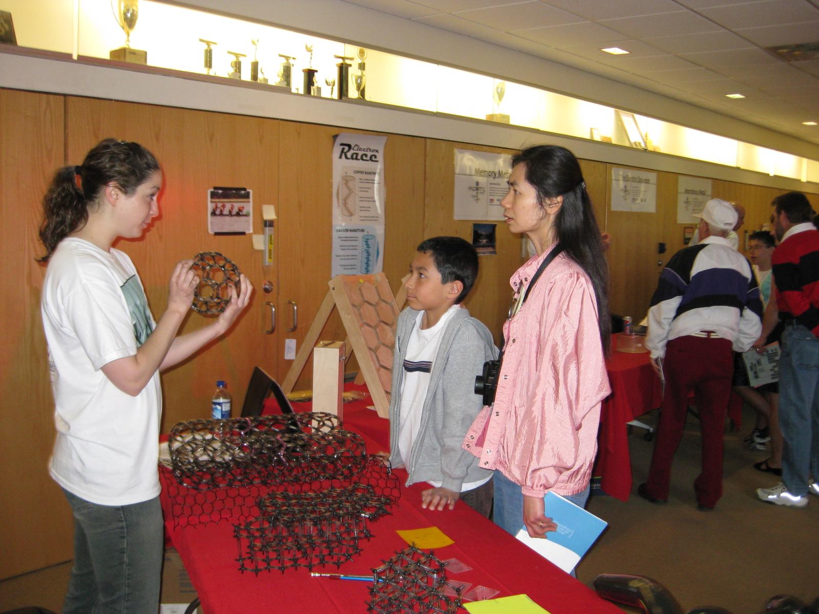 Facilitator shows a buckyball model to learners 