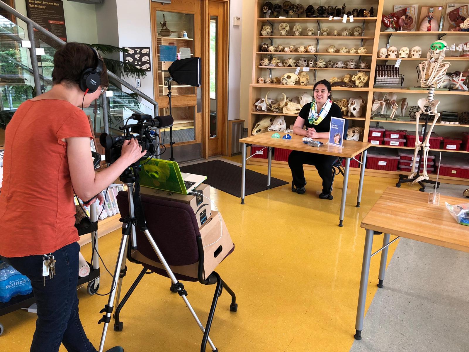 A behind the scenes perspective of filming a Chemistry training video with a videographer filming and educator explaining a chemistry related activity