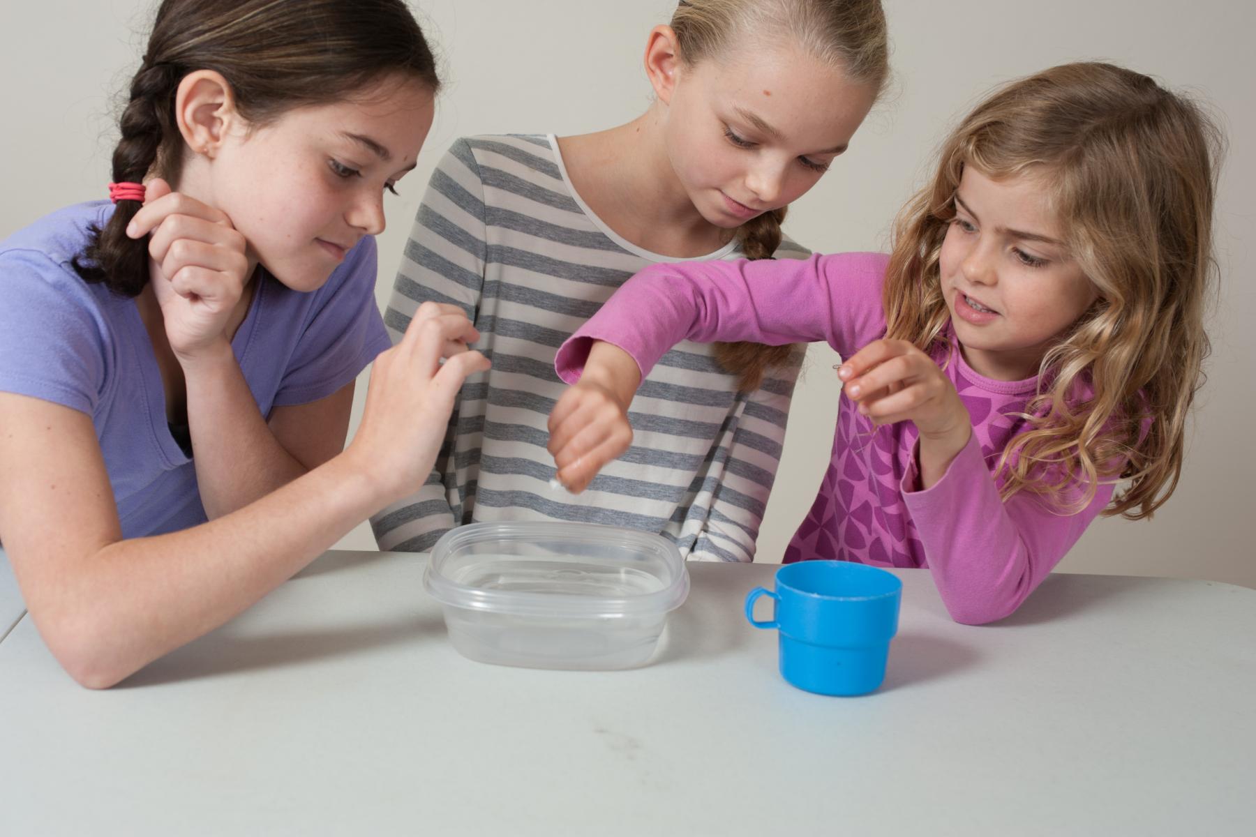 young learners placing mini teacup in water to see what happens