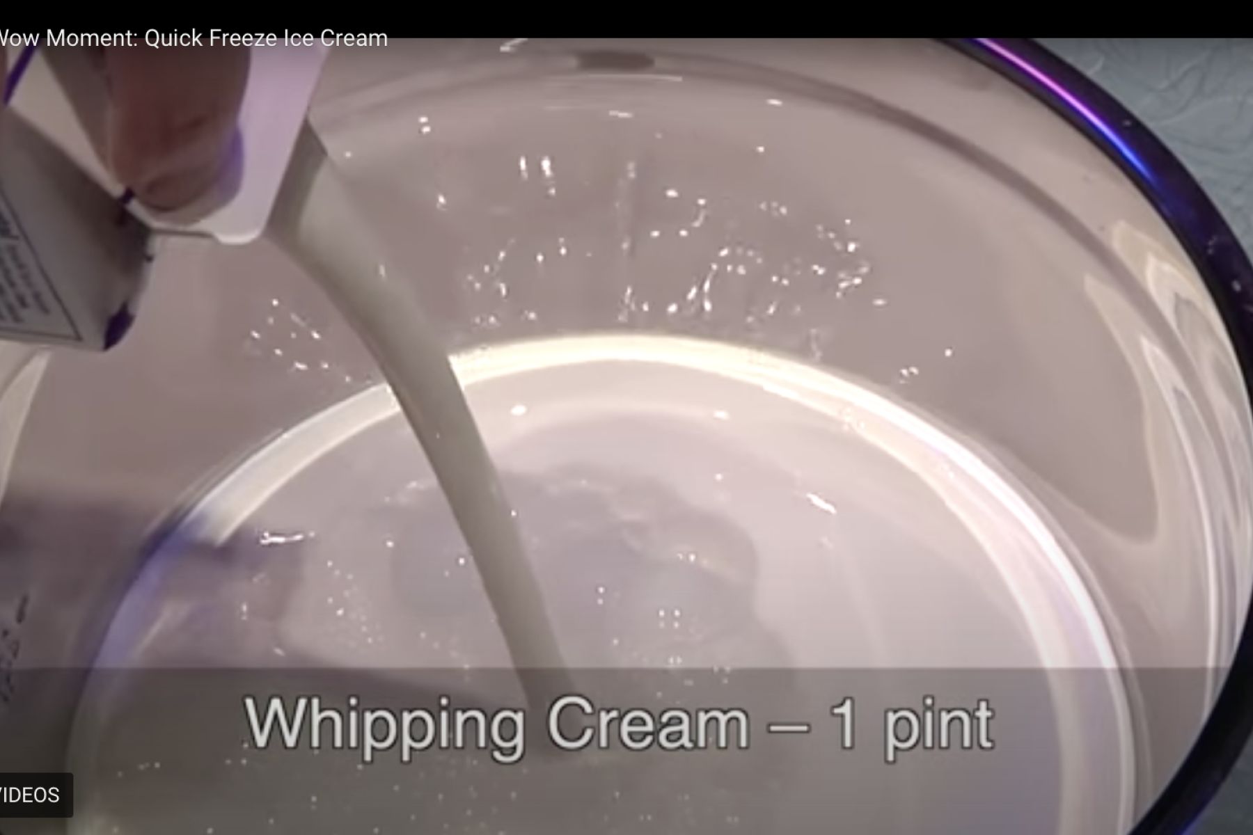 Nano ice cream activity Mr. O video screenshot showing presenter 's hand pouring whipping cream into bowl