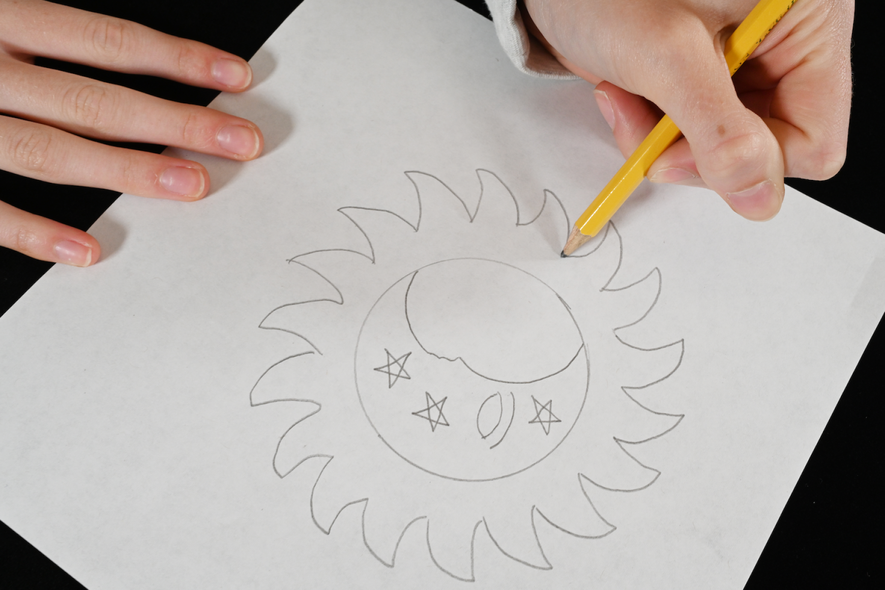 Ancestral Astronomy learner hand drawing design with pencil on paper.