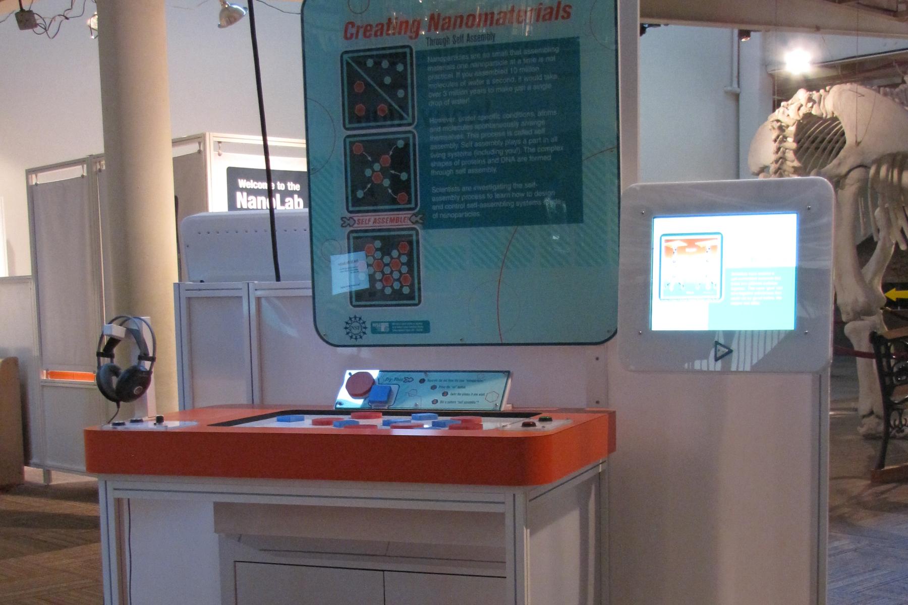 Creating Nanomaterials exhibit as viewed from the right with a stool placed in front of it.