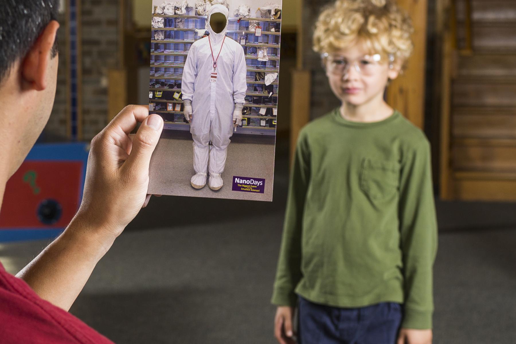 Parent holding card to simulate child dressed as a nonscientist in Dress up like a Nanoscientist NanoDays activity
