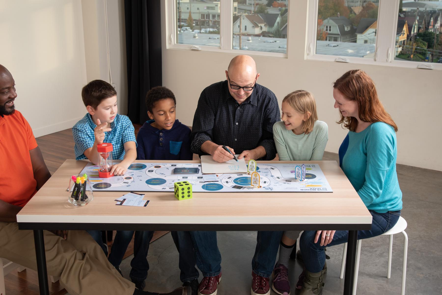 a family of six plays the mission to space board game at a table