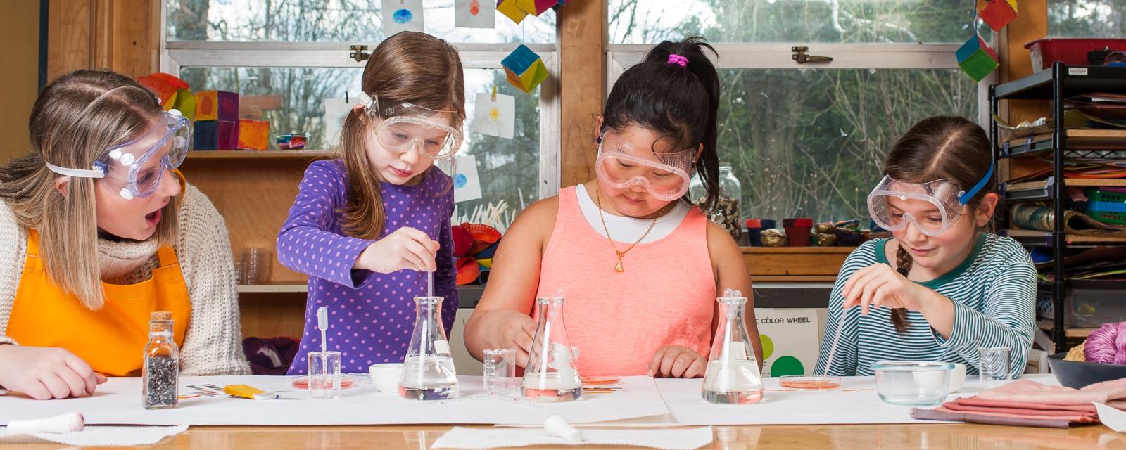 Childrens using Nature of Dye chemistry activity with tools and glassware