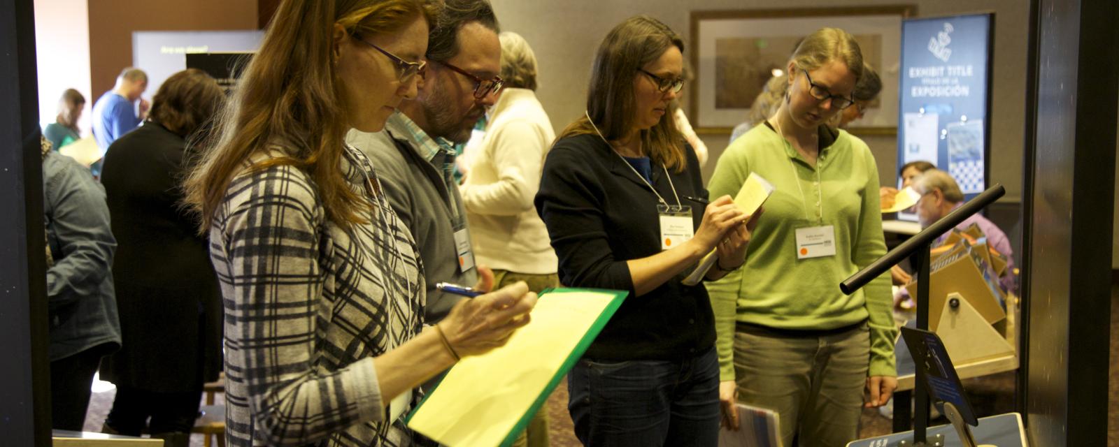 Group of people with clipboards writing 