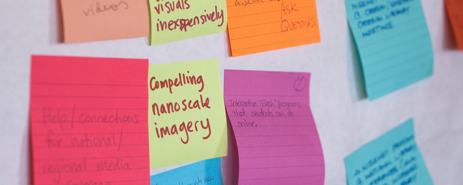 Colorful Sticky notes on a wall with writing on the notes